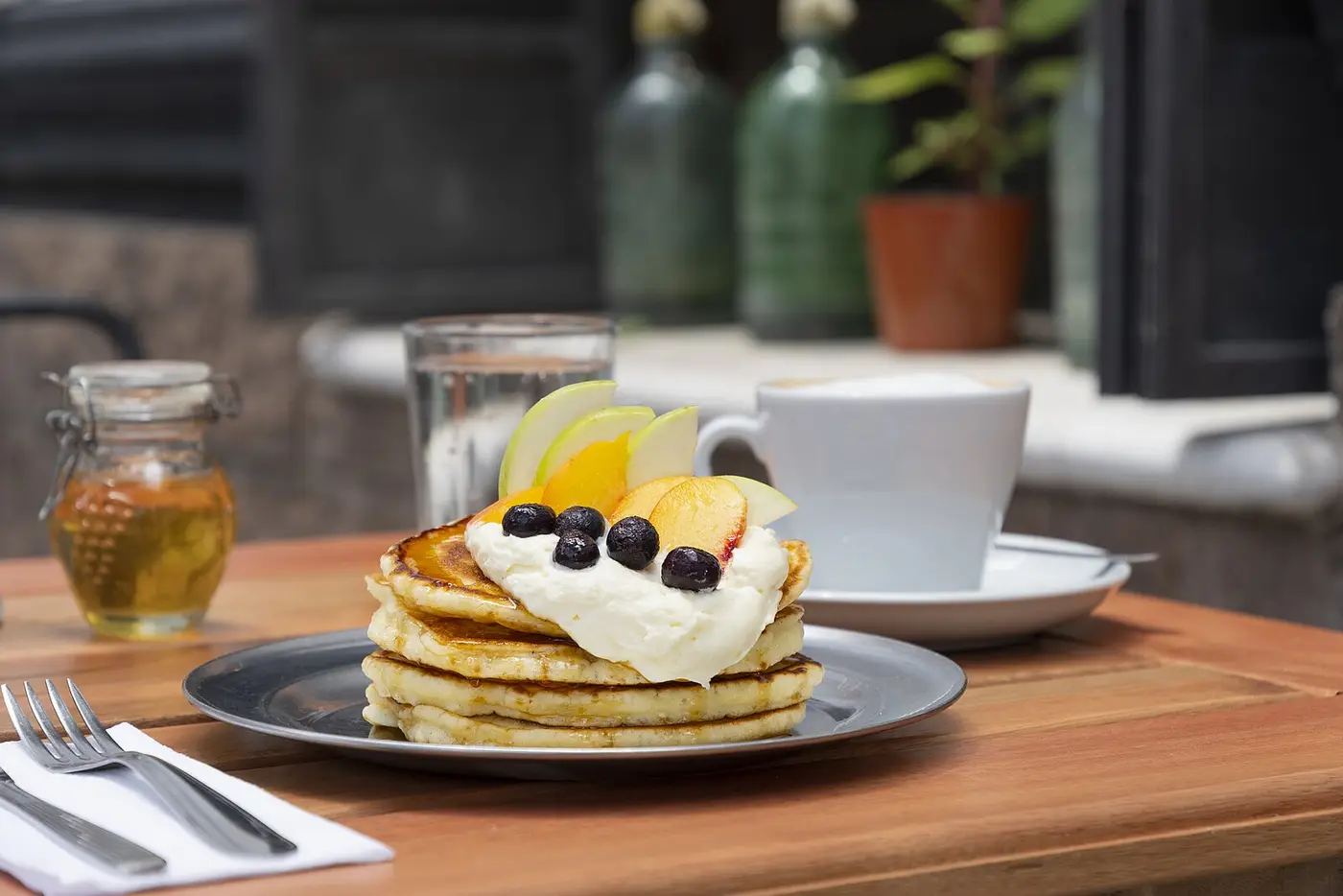 A stack of pancakes with fruit and a cup of coffee. The photo was not taken at a Panama City restaurant.
