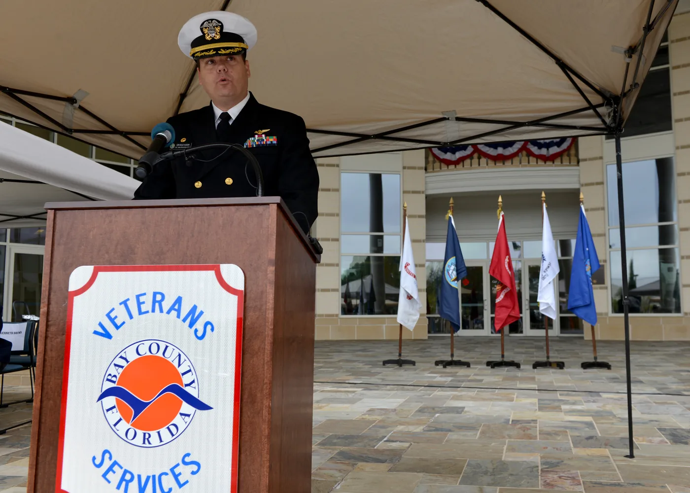 The commanding officer of Naval Support Activity Panama City speaks at a Bay County Veterans Services podium before a Veterans Day parade in Panama City.