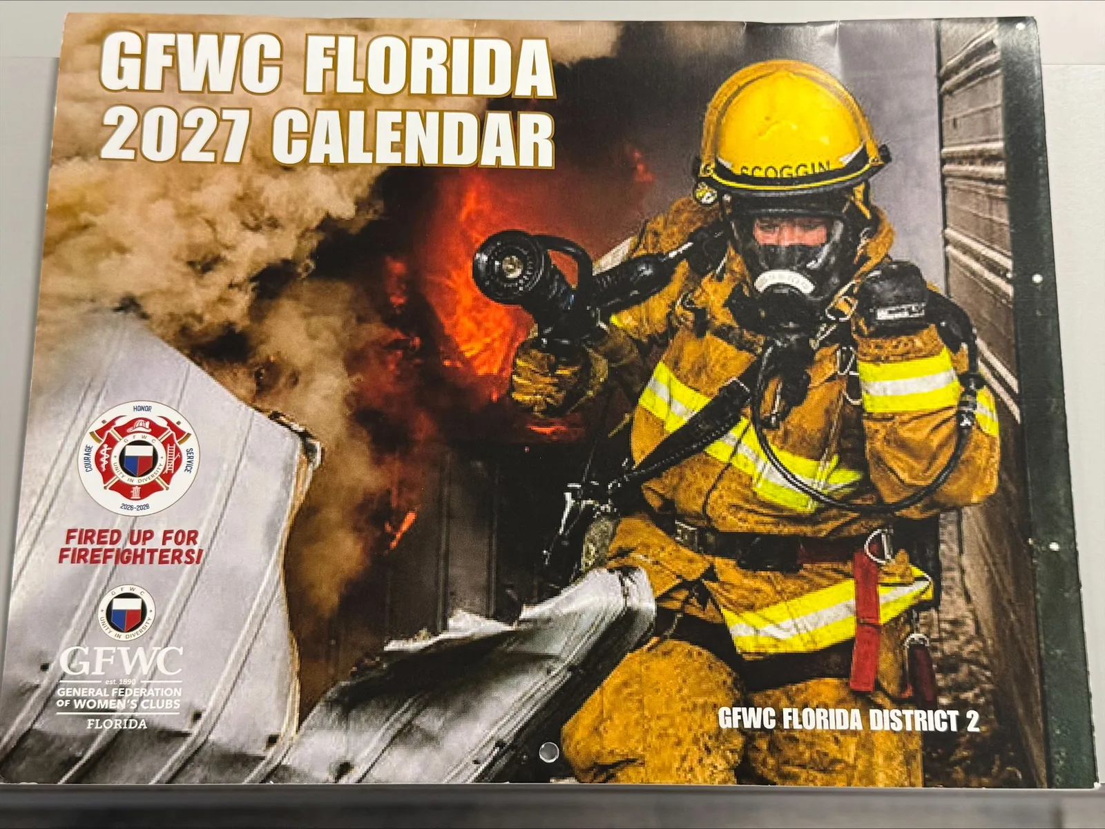 The GFWC Florida 2027 calendar cover, showing Panama City Fire Department Driver Engineer Amanda Scoggin at a structure fire.